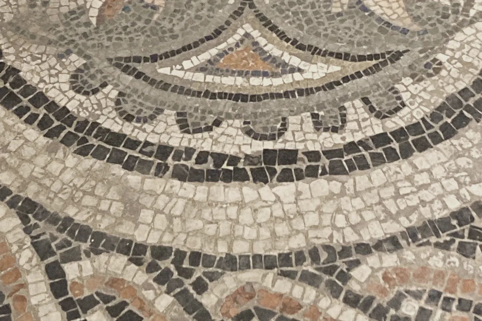 A curved mosaic floor pattern made of small stone tiles.